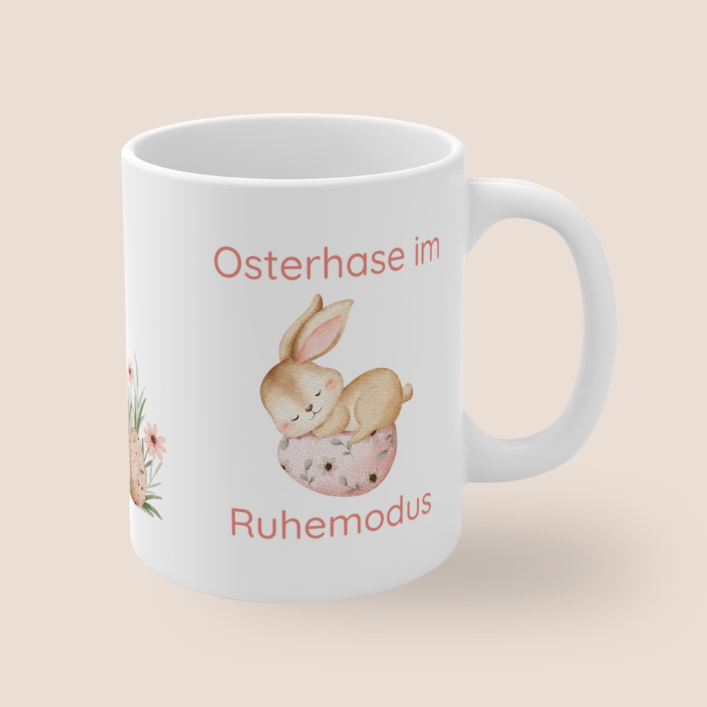 Weiße Keramiktasse mit dem Spruch „Osterhase im Ruhemodus“ und einem niedlichen schlafenden Aquarell-Hasen auf einem Osterei – 300-ml-Keramiktasse für Ostern.