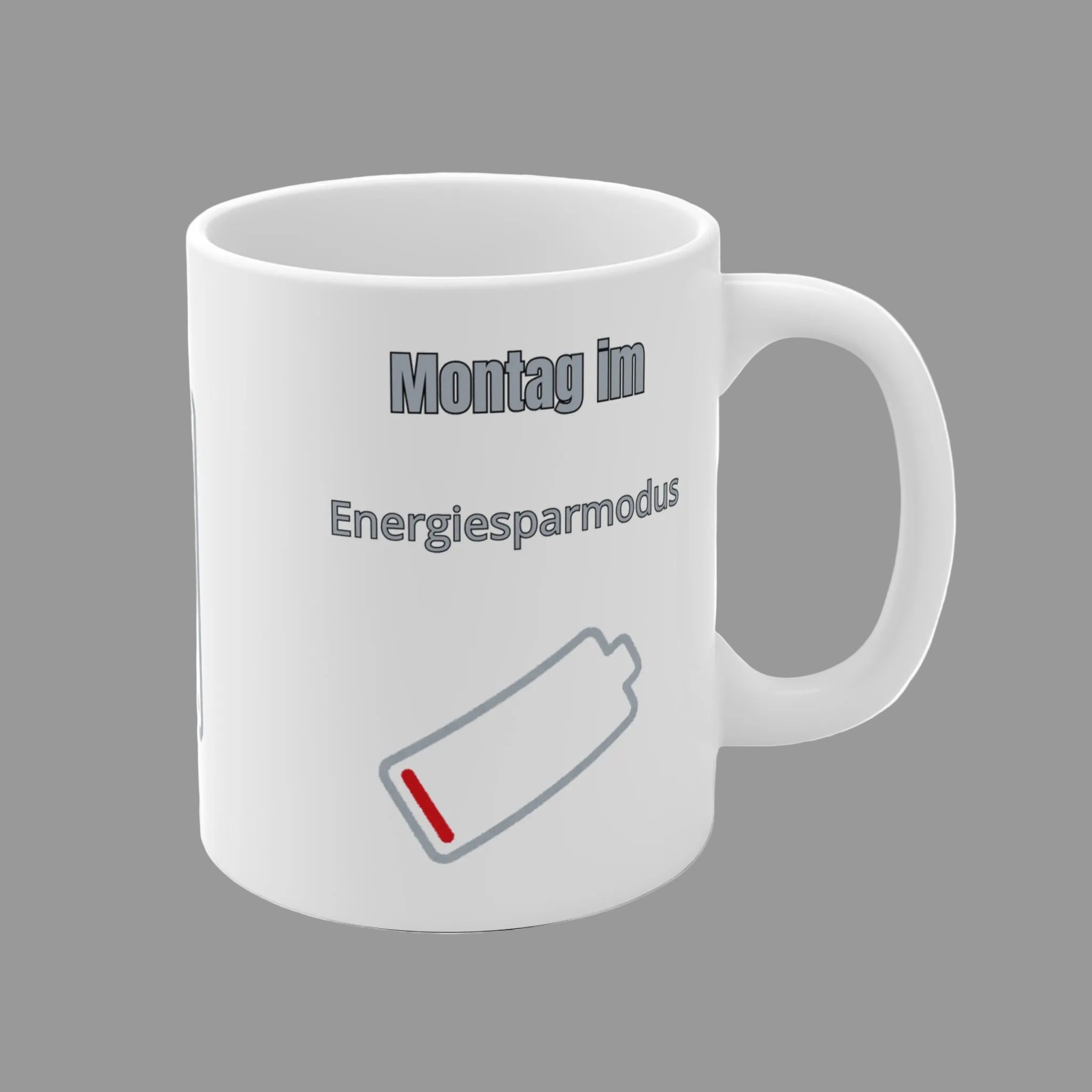 Weiße 300-ml-Keramiktasse mit dem Spruch „Montag im Energiesparmodus“ und einem fast leeren Batteriesymbol – lustige Bürotasse für den Wochenstart.
