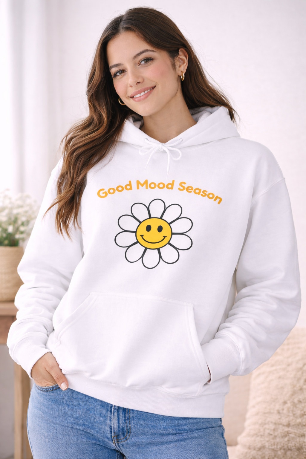 Weißer Unisex-Hoodie mit gelbem Smiley-Blumenmotiv und dem Schriftzug „Good Mood Season“ auf der Vorderseite.