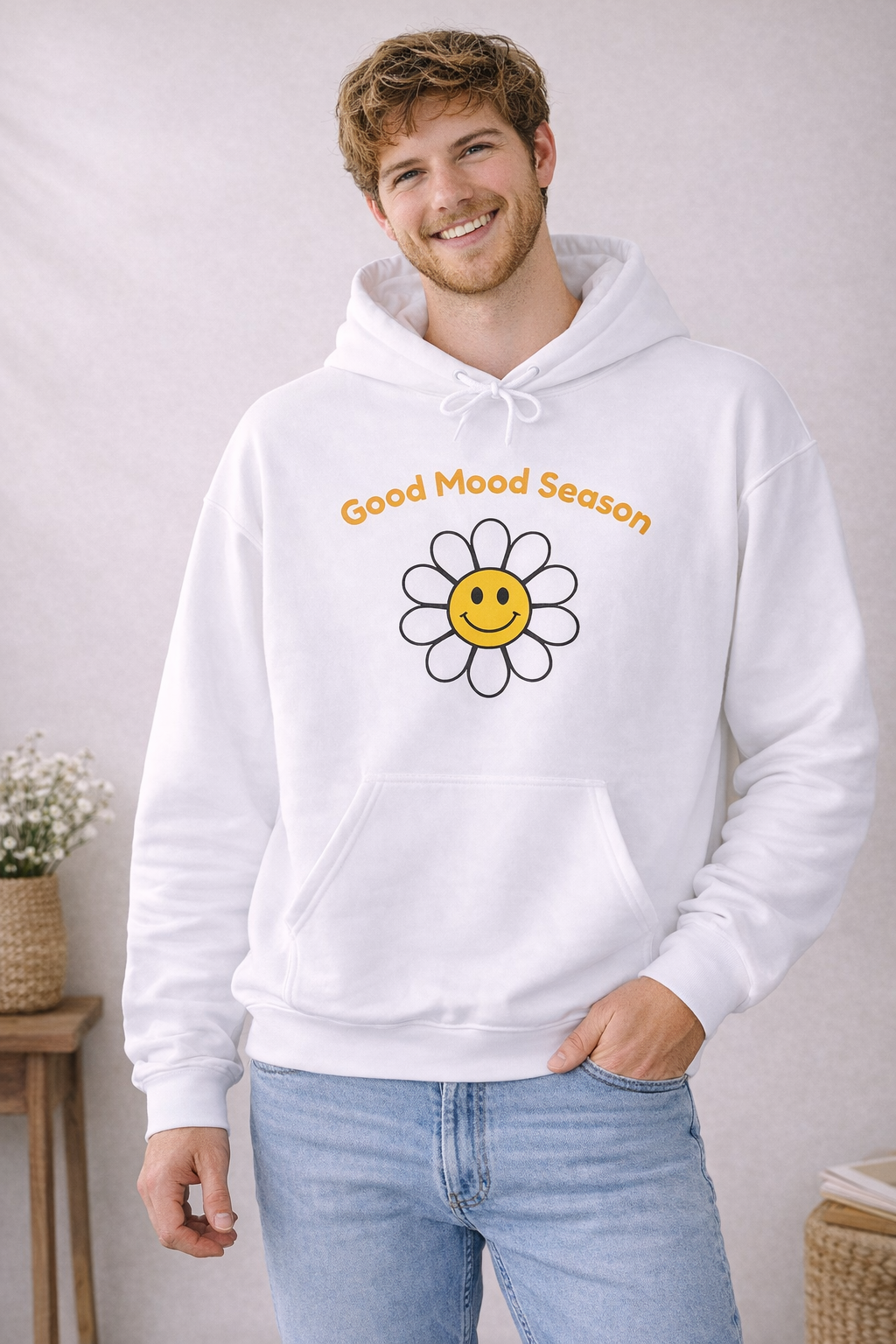 Weißer Unisex-Hoodie mit gelbem Smiley-Blumenmotiv und dem Schriftzug „Good Mood Season“ auf der Vorderseite.