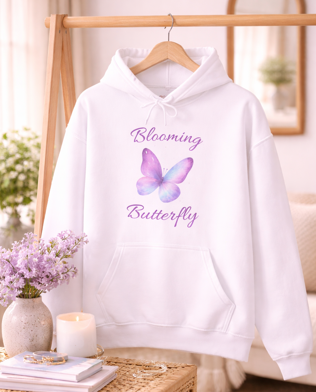 Weißer Unisex-Hoodie mit lila Schmetterlingsmotiv und dem Schriftzug „Blooming Butterfly“ auf der Vorderseite.