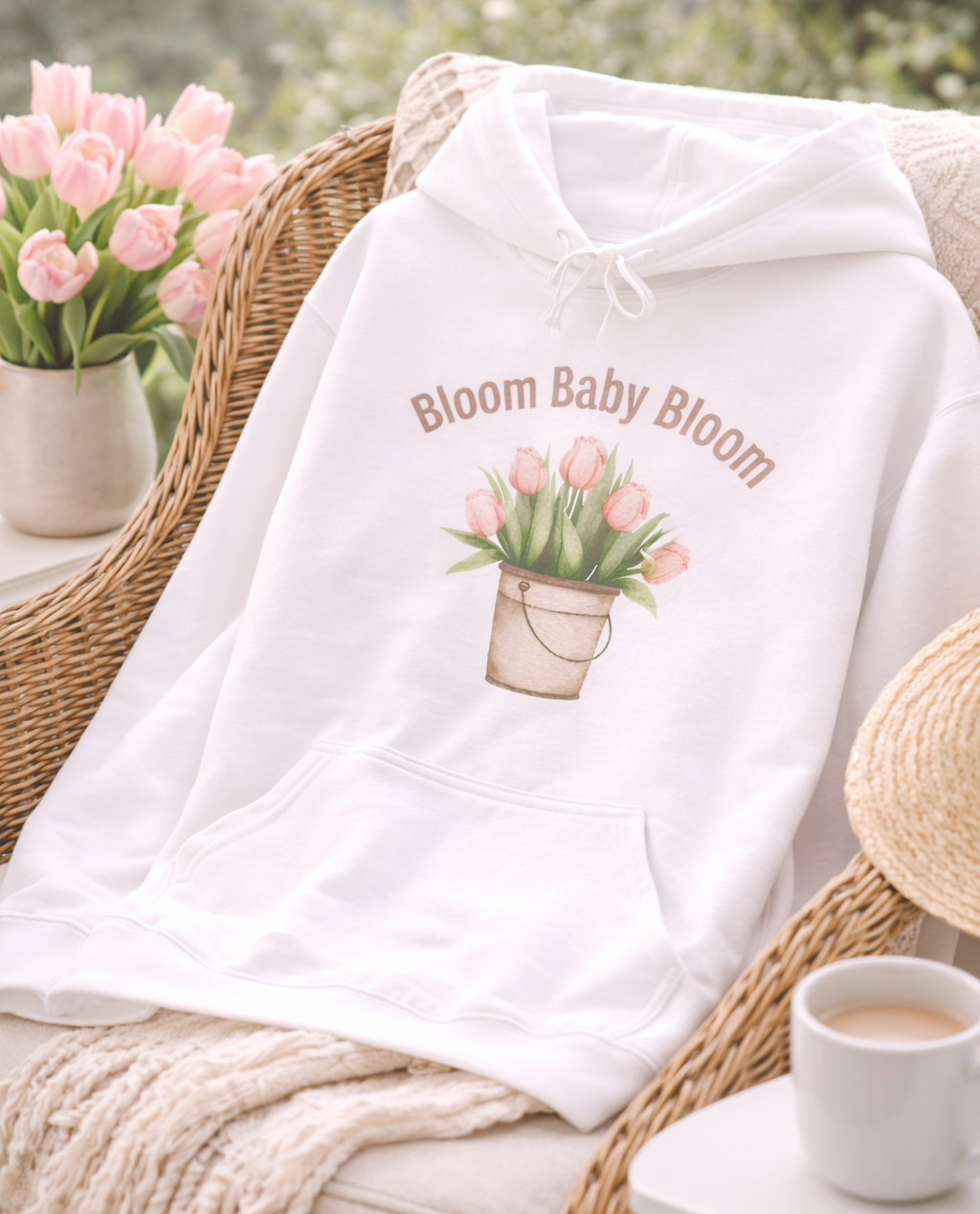 Weißer Unisex-Hoodie mit Tulpenmotiv im Blumentopf und dem Schriftzug „Bloom Baby Bloom“ auf der Vorderseite.