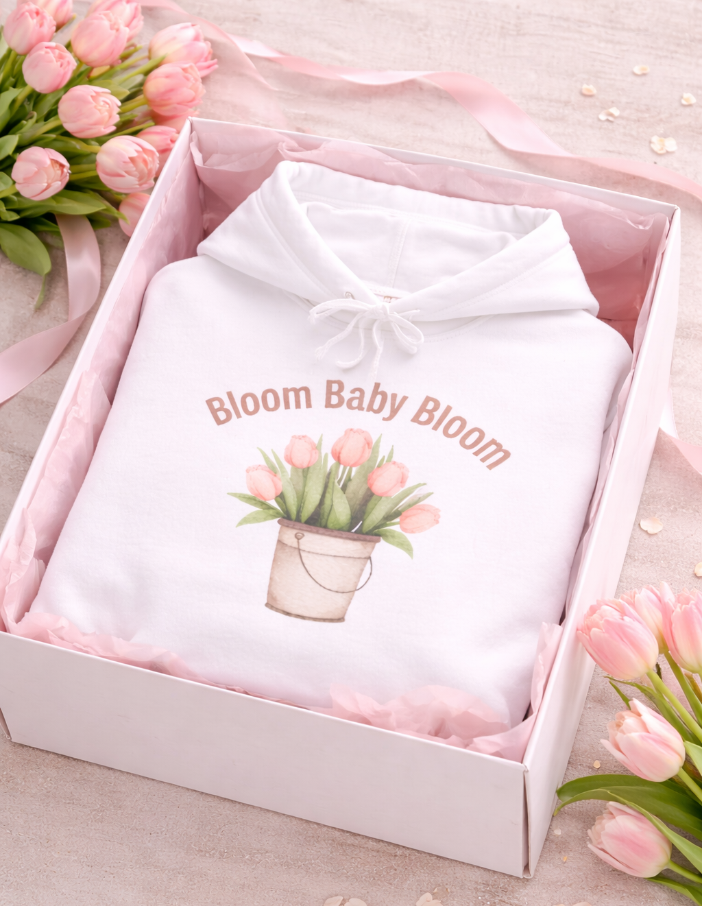 Weißer Unisex-Hoodie mit Tulpenmotiv im Blumentopf und dem Schriftzug „Bloom Baby Bloom“ auf der Vorderseite.