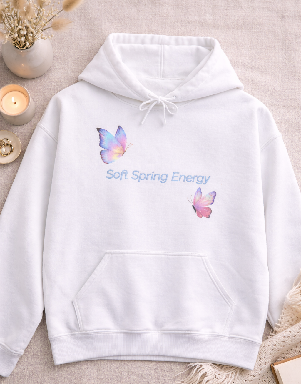 Weißer Unisex-Hoodie mit zwei bunten Schmetterlingen in Pastelltönen und dem Schriftzug „Soft Spring Energy“ auf der Vorderseite.