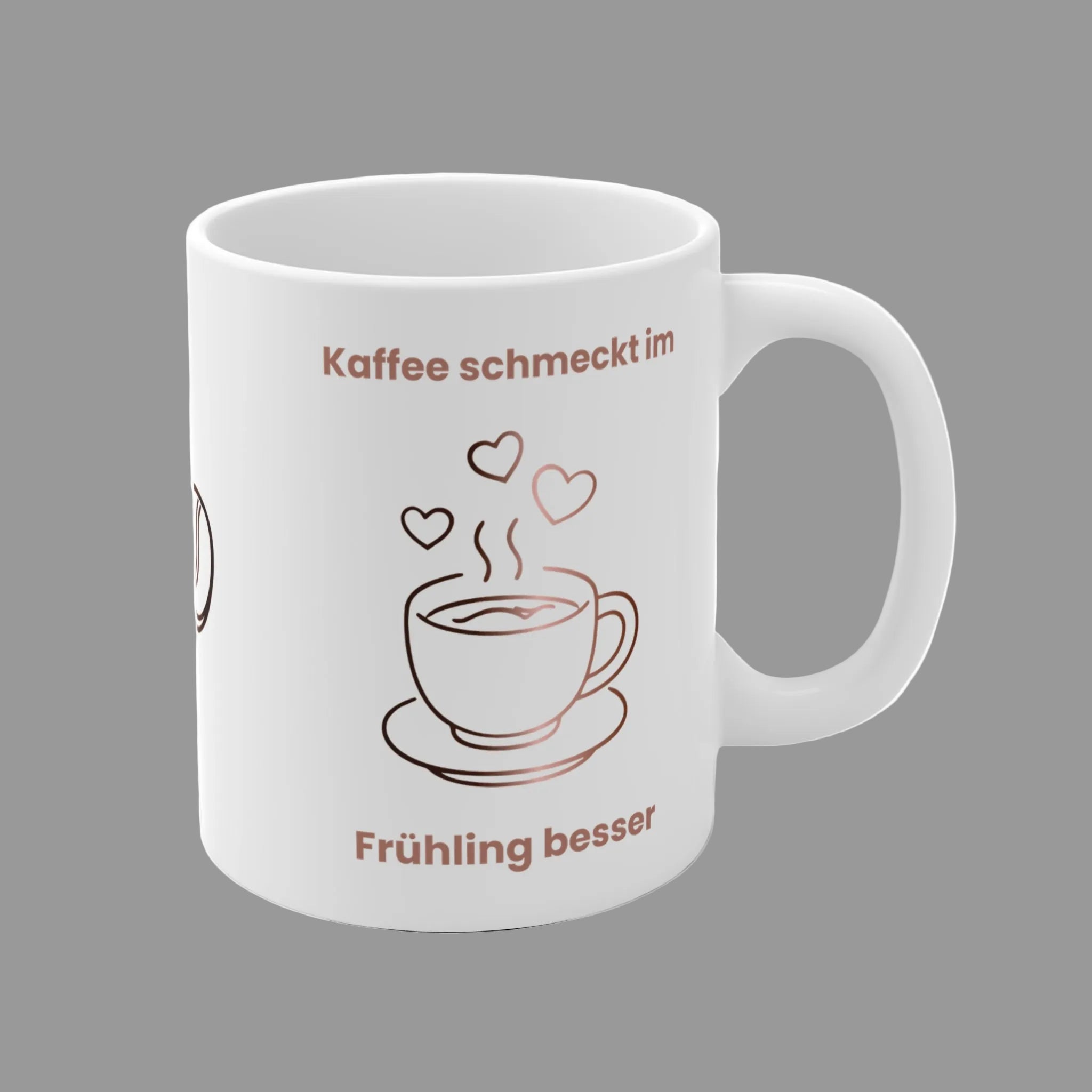 Weiße Keramiktasse mit dem Spruch „Kaffee schmeckt im Frühling besser“, einer minimalistischen Kaffeetasse, Kaffeebohnen und Herzmotiven in warmen Braun- und Rosatönen.