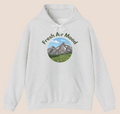 Weißer oder aschgrauer Unisex Hoodie mit dem Schriftzug „Fresh Air Mood“ und Berglandschaft-Motiv für Wanderer, Naturliebhaber und Outdoor-Fans.