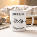 Weiße 300-ml-Keramiktasse mit dem Spruch „Donnerstag fast geschafft“ und zwei schwarz-weißen Zielflaggen – lustige Bürotasse für den Countdown zum Wochenende.