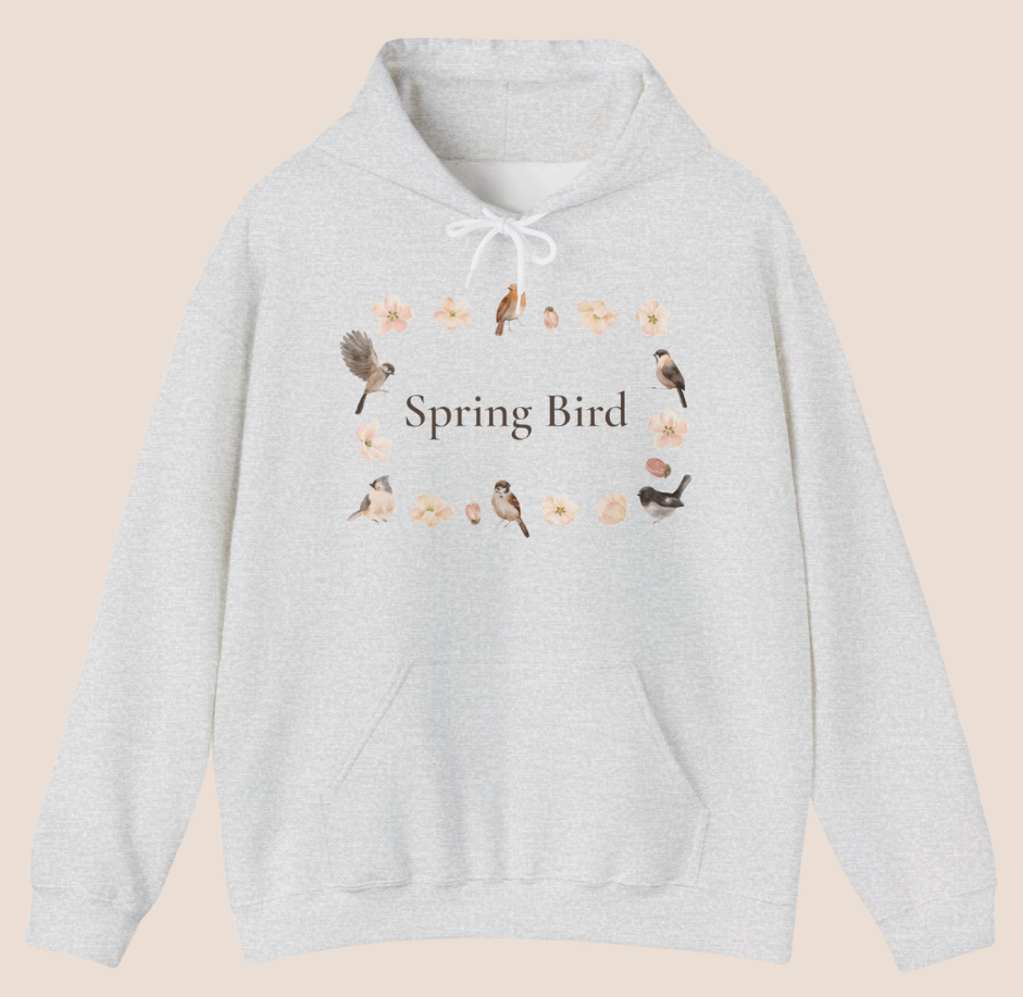 Weißer Unisex-Hoodie mit dem Schriftzug „Spring Bird“, umgeben von kleinen Vögeln und zarten Blütenmotiven in einem Frühlingskranz.