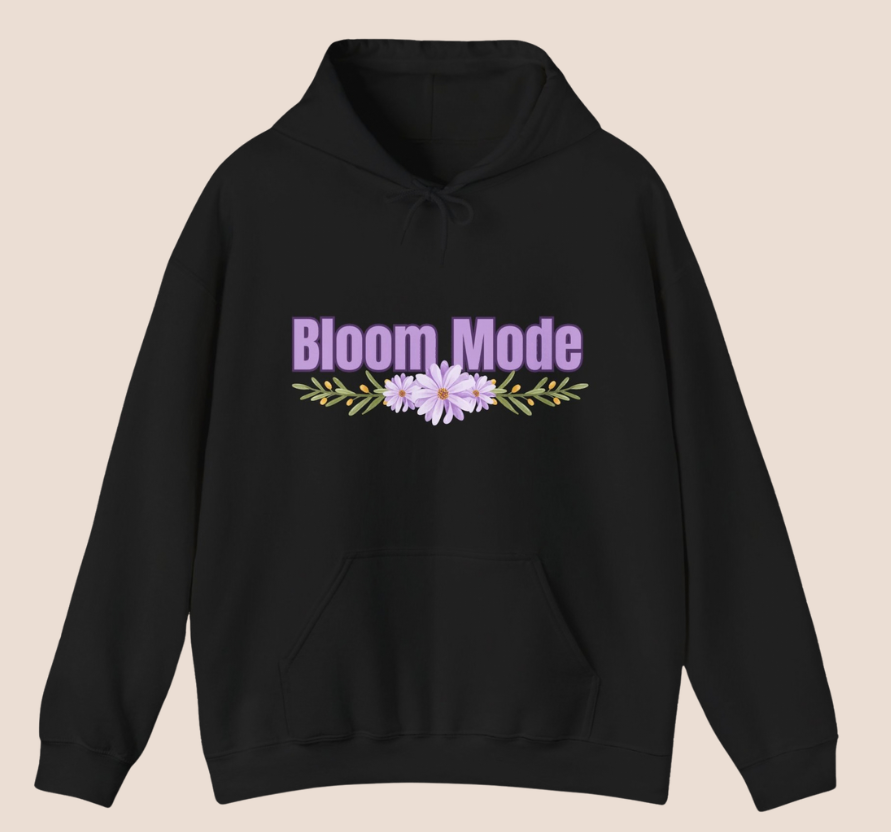 Schwarzer Unisex-Hoodie mit dem Schriftzug „Bloom Mode“ und einem floralen Blumenmotiv in Lilatönen auf der Vorderseite.