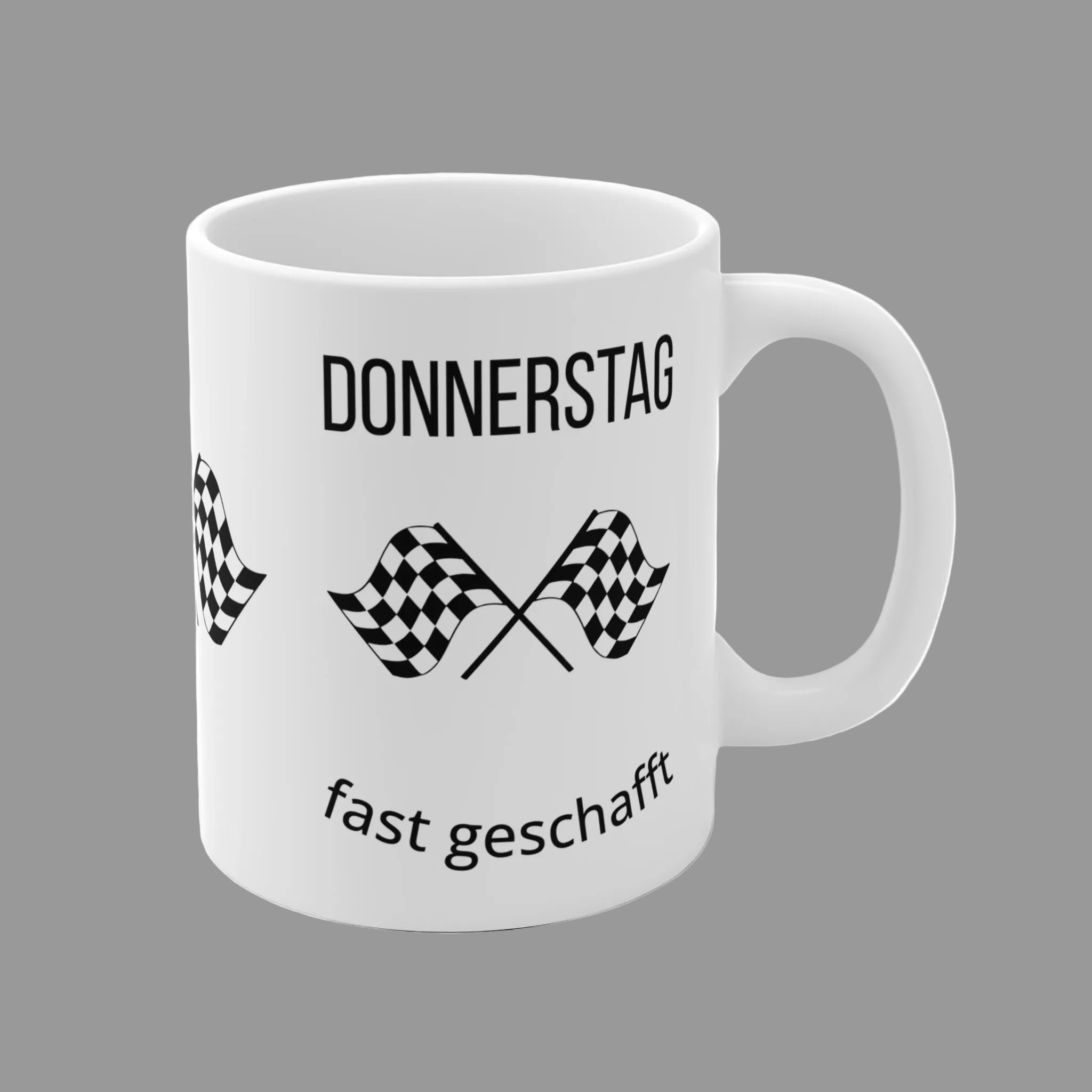 Weiße 300-ml-Keramiktasse mit dem Spruch „Donnerstag fast geschafft“ und zwei schwarz-weißen Zielflaggen – lustige Bürotasse für den Countdown zum Wochenende.