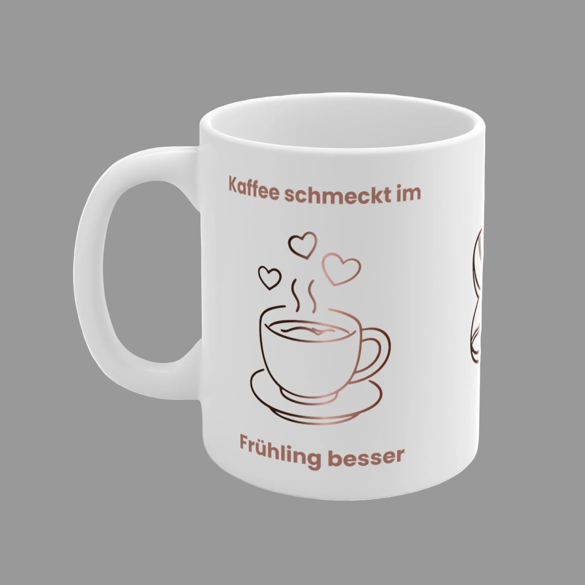 Weiße Keramiktasse mit dem Spruch „Kaffee schmeckt im Frühling besser“, einer minimalistischen Kaffeetasse, Kaffeebohnen und Herzmotiven in warmen Braun- und Rosatönen.