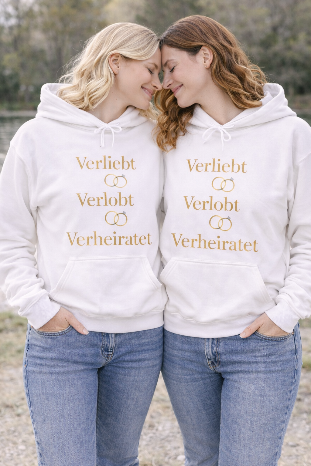 Weißer Unisex Hoodie mit dem eleganten Schriftzug „Verliebt Verlobt Verheiratet“ und dezenten Eheringen – romantischer Hoodie für Paare und Hochzeiten.