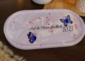 Großes handgefertigtes Deko-Tablett in Lila-Weiß mit Glitzer, drei eingelassenen Schmetterlingen, Schmetterlings-Rub-Ons und dem Spruch „Auf die Plätze glücklich JETZT“, Keramik Einzelstück mit einer Breite von ca. 23 cm.