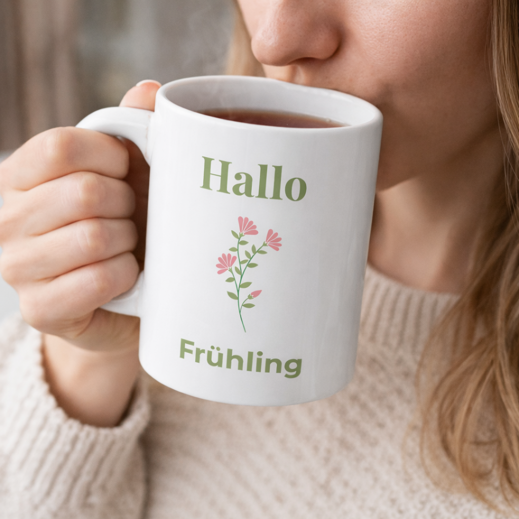 Weiße Keramiktasse mit dem Schriftzug „Hallo Frühling“ und einem zarten rosa Blumenmotiv – frühlingshafte 300-ml-Tasse für Kaffee oder Tee.
