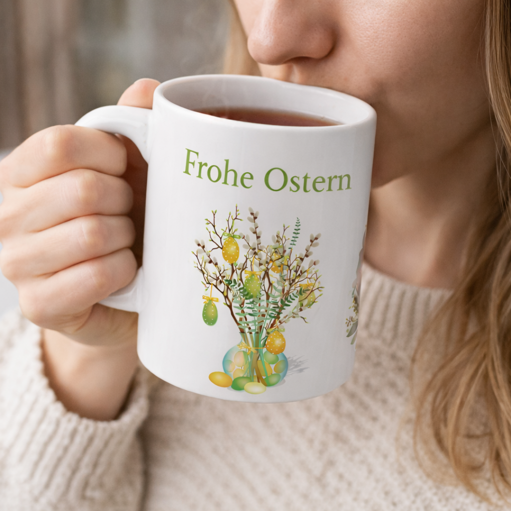 Weiße Keramiktasse mit dem Schriftzug „Frohe Ostern“, einem niedlichen Aquarell-Hasen mit Blumenkranz sowie dekorativen Osterzweigen mit bunten Ostereiern – 300-ml-Ostertasse.