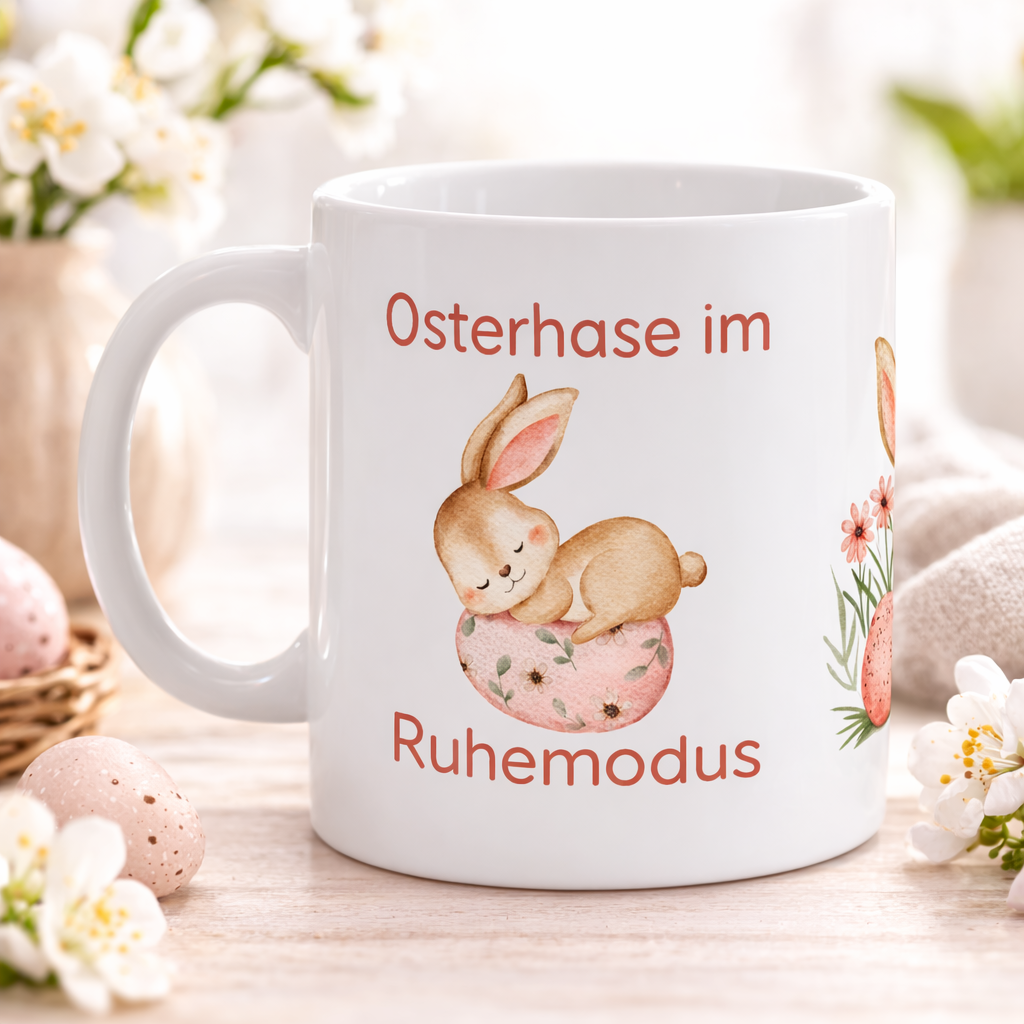 Weiße Keramiktasse mit dem Spruch „Osterhase im Ruhemodus“ und einem niedlichen schlafenden Aquarell-Hasen auf einem Osterei – 300-ml-Keramiktasse für Ostern.