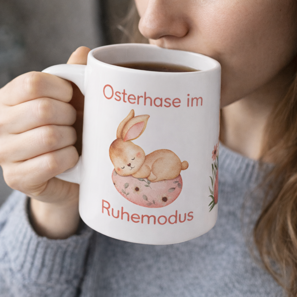 Weiße Keramiktasse mit dem Spruch „Osterhase im Ruhemodus“ und einem niedlichen schlafenden Aquarell-Hasen auf einem Osterei – 300-ml-Keramiktasse für Ostern.