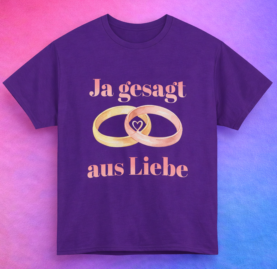 Unisex T-Shirt mit dem Schriftzug „Ja gesagt aus Liebe“ und zwei ineinander verschlungenen Eheringen in Gold und Roségold als romantisches Hochzeitsmotiv.