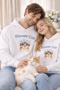 Weißer Unisex-Hoodie mit süßer Katze, blauem Blumenkranz und dem Schriftzug „Flower Cat“ auf der Vorderseite.