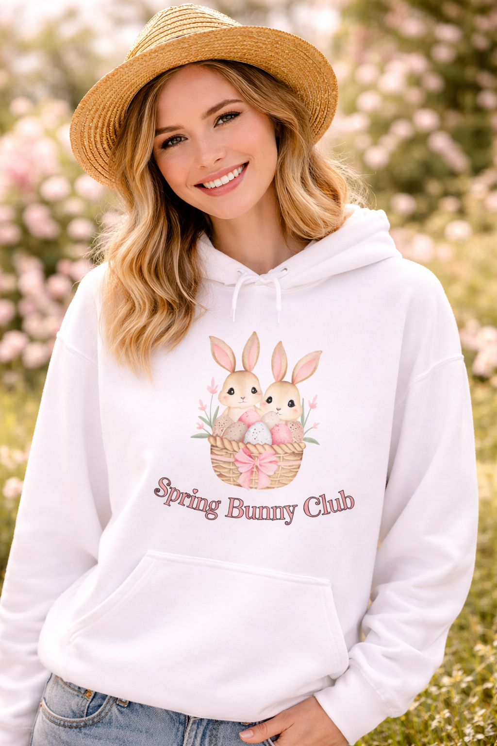 Weißer Unisex-Hoodie mit zwei süßen Hasen in einem Osterkörbchen und dem Schriftzug „Spring Bunny Club“ auf der Vorderseite.