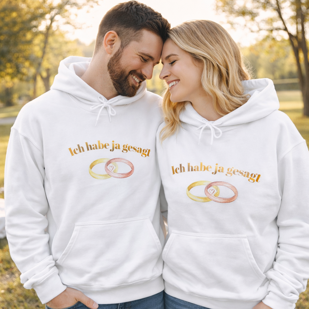 Weißer Unisex Hoodie mit dem Schriftzug „Ich habe Ja gesagt“ und zwei ineinander verschlungenen Eheringen als romantisches Hochzeitsmotiv.