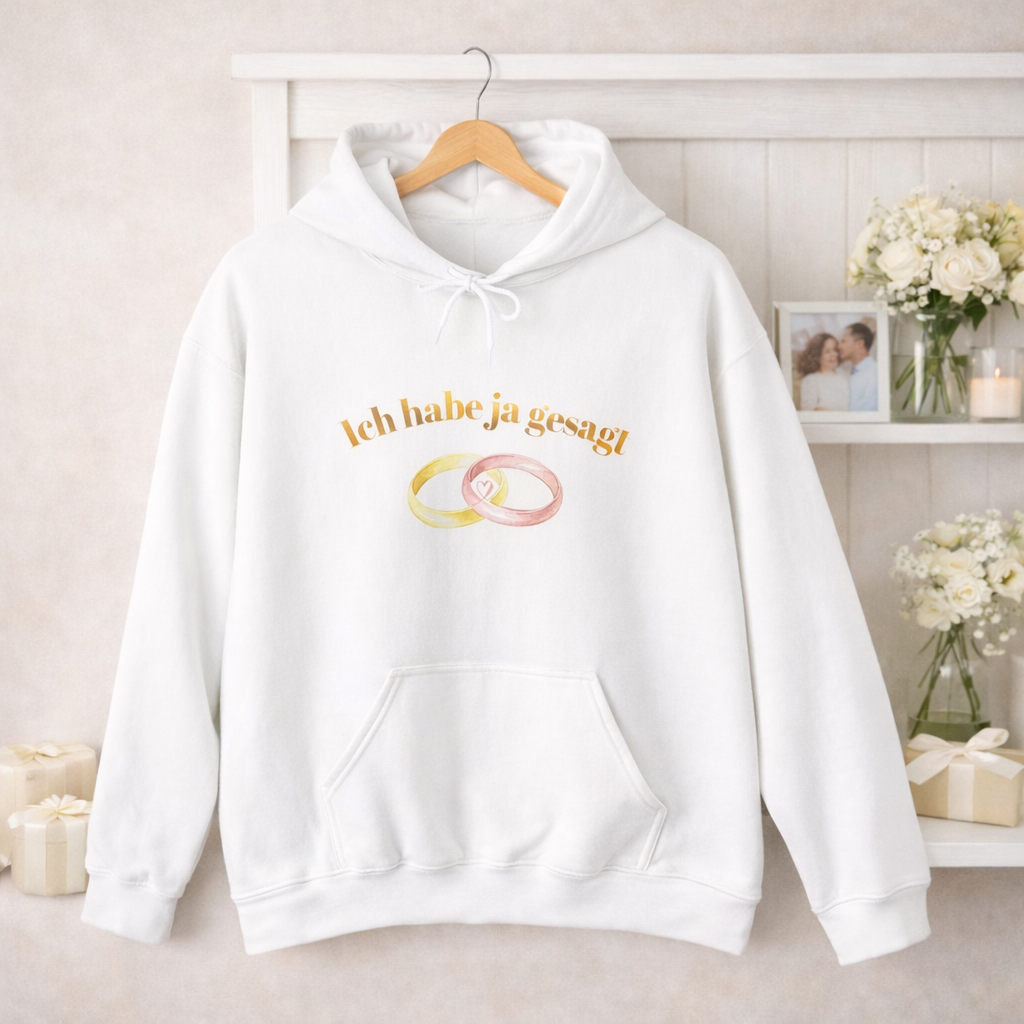 Weißer Unisex Hoodie mit dem Schriftzug „Ich habe Ja gesagt“ und zwei ineinander verschlungenen Eheringen als romantisches Hochzeitsmotiv.