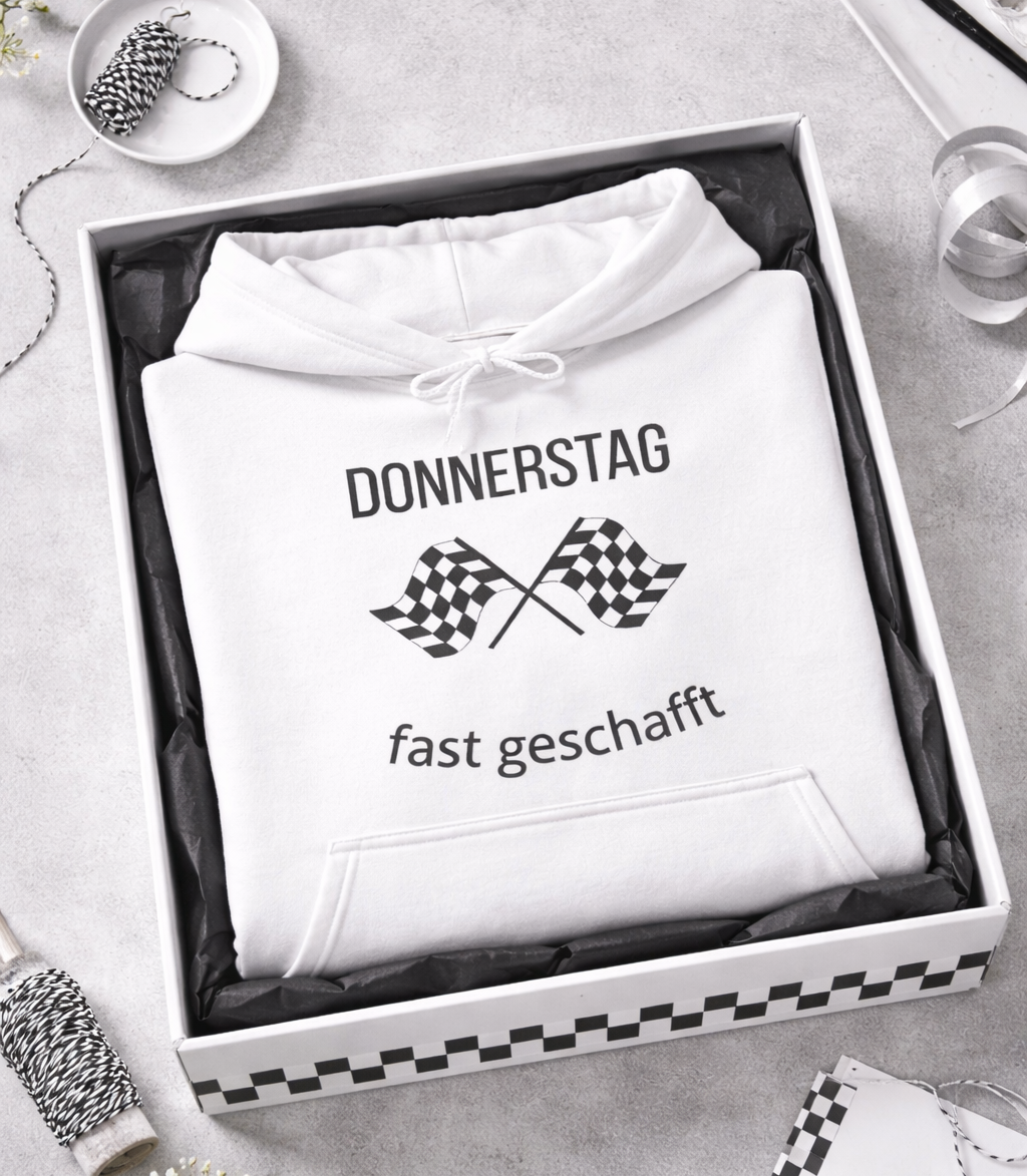 Weißer Hoodie mit dem Spruch „Donnerstag – fast geschafft“ und zwei Zielflaggen als Motiv.