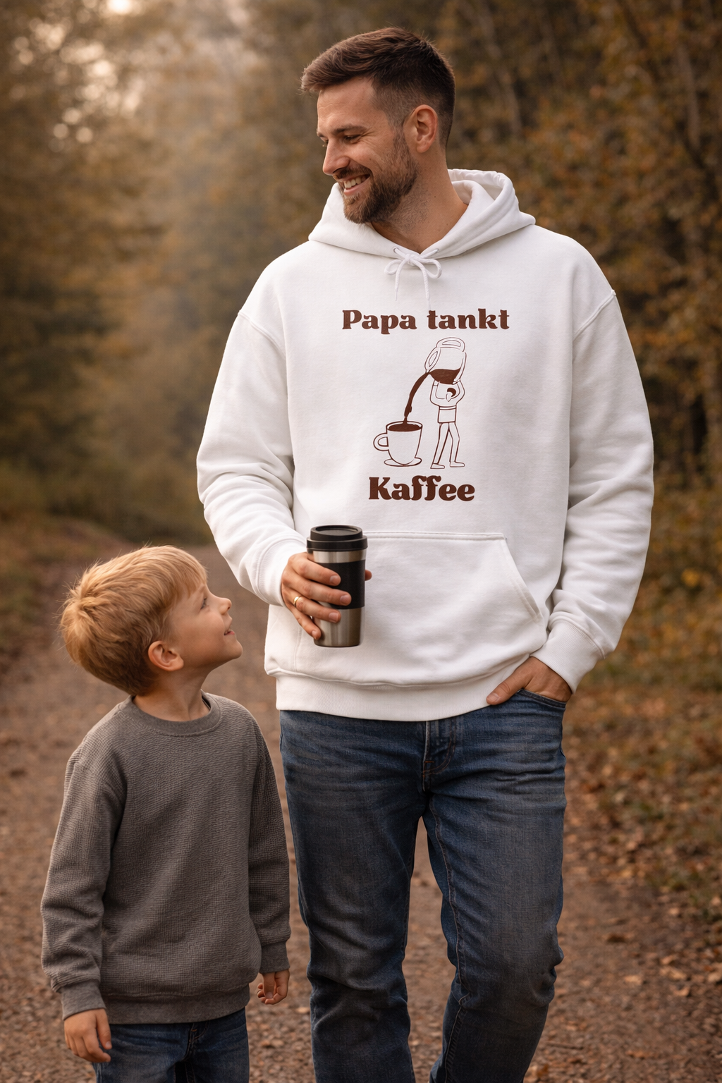 Weißer Hoodie mit dem Spruch „Papa tankt Kaffee“ und einer Illustration einer Kaffeekanne, die Kaffee in eine Tasse einschenkt.