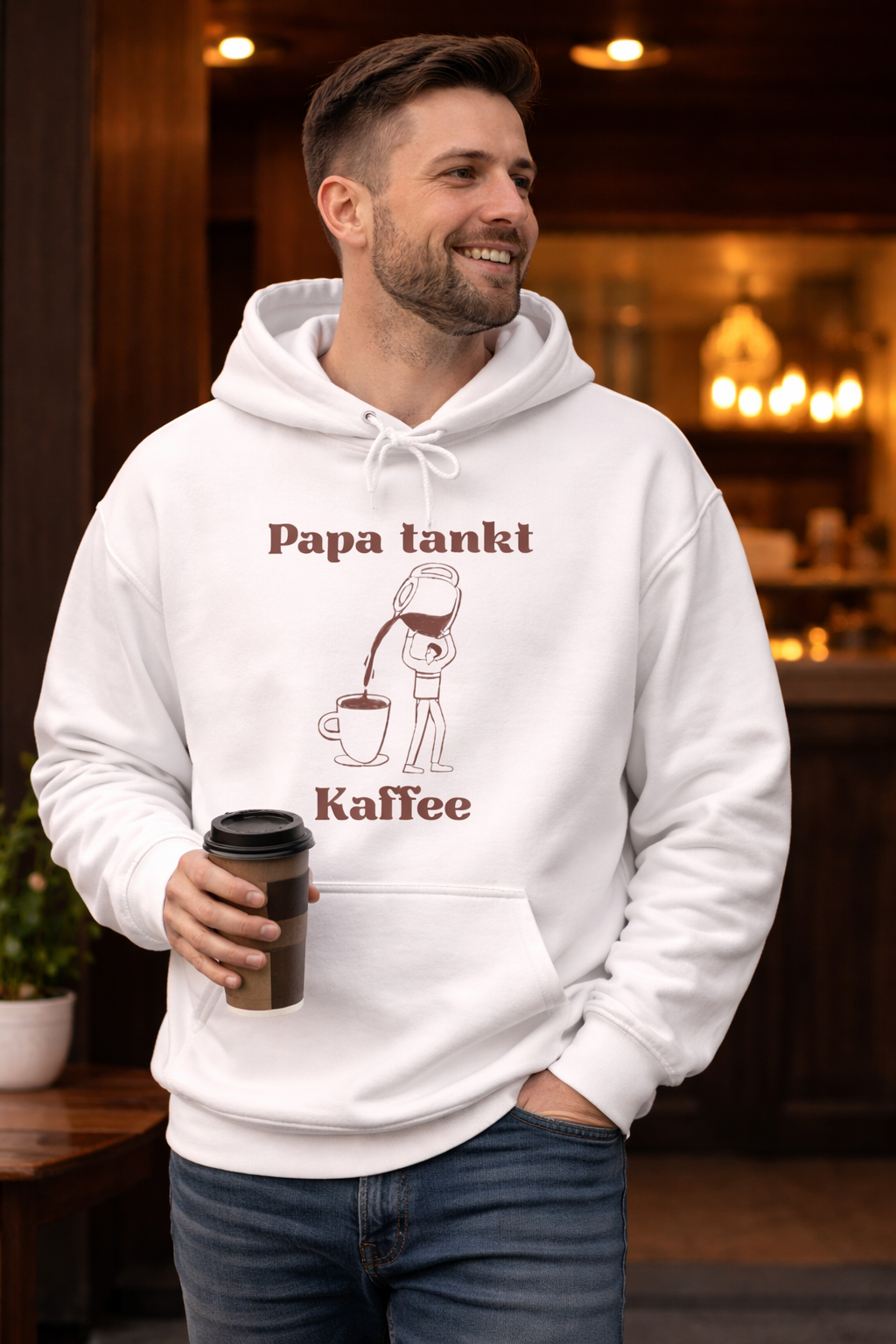 Weißer Hoodie mit dem Spruch „Papa tankt Kaffee“ und einer Illustration einer Kaffeekanne, die Kaffee in eine Tasse einschenkt.