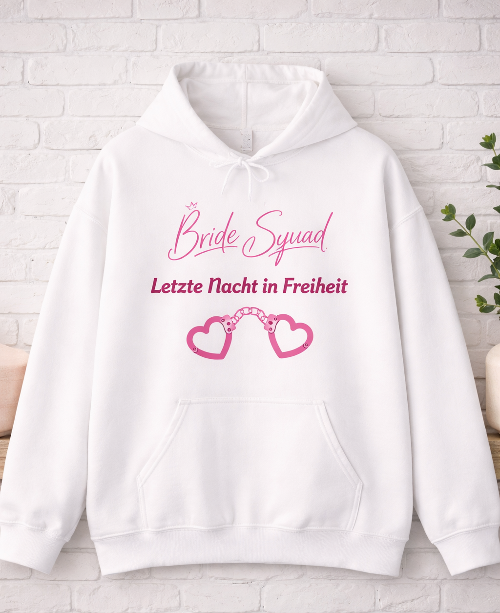 Weißer Unisex-Hoodie mit dem Schriftzug „Bride Squad – Letzte Nacht in Freiheit“ und rosa Herz-Handschellen als Motiv – ideal für den Junggesellinnenabschied.