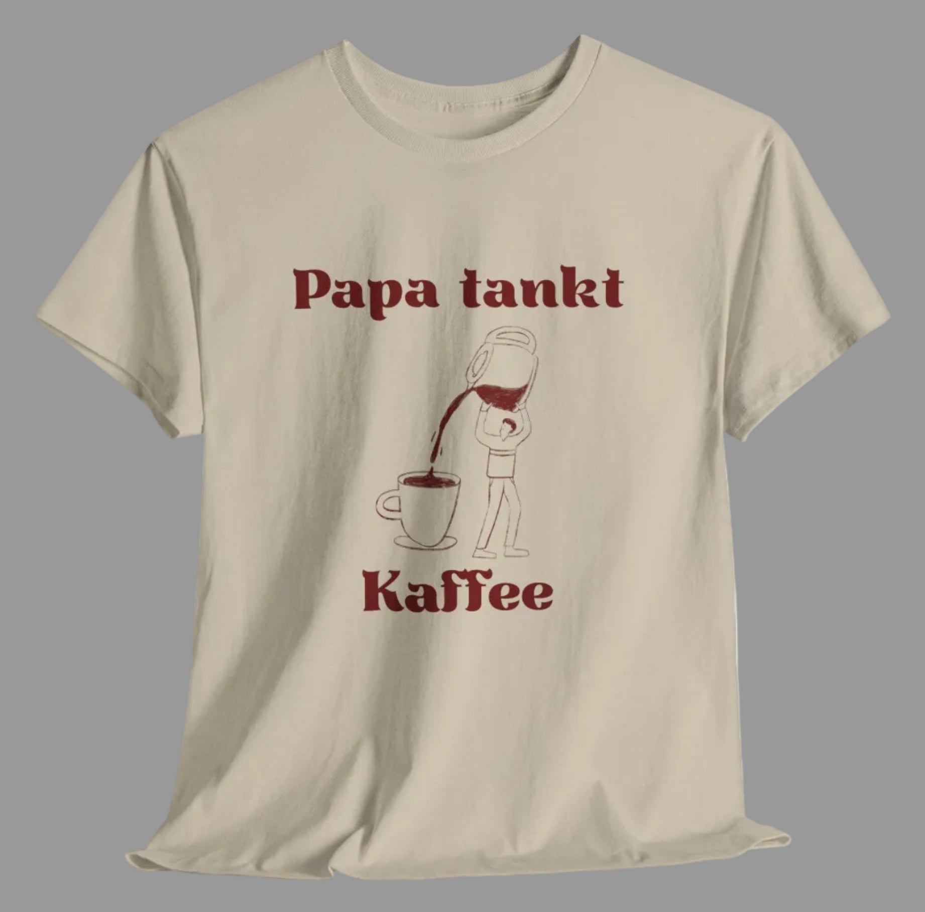 Weißes und sandfarbenes Unisex T-Shirt mit dem Aufdruck „Papa tankt Kaffee“ und einer humorvollen Illustration einer Person, die Kaffee aus einer großen Kanne in eine Tasse gießt.