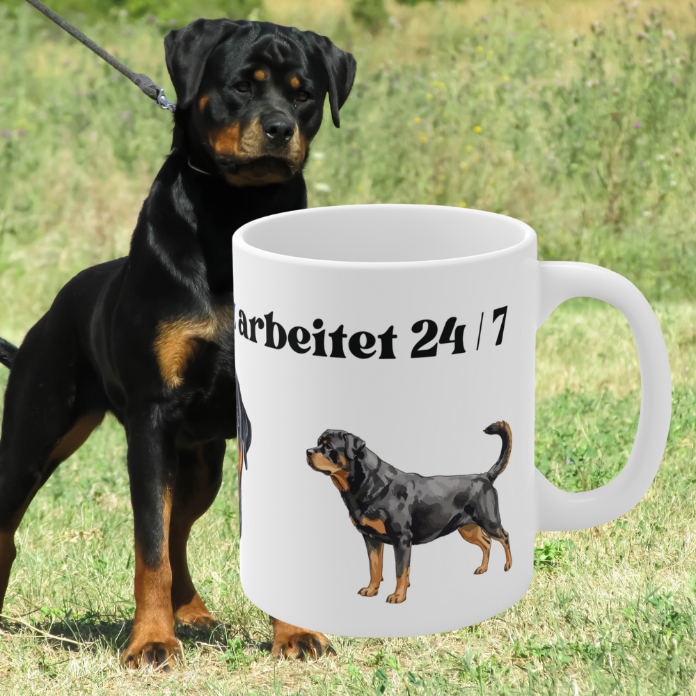 Weiße 330 ml Keramiktasse mit dem Spruch „Mein Wachschutz arbeitet 24/7“ sowie detailreichen Illustrationen eines Rottweilers.