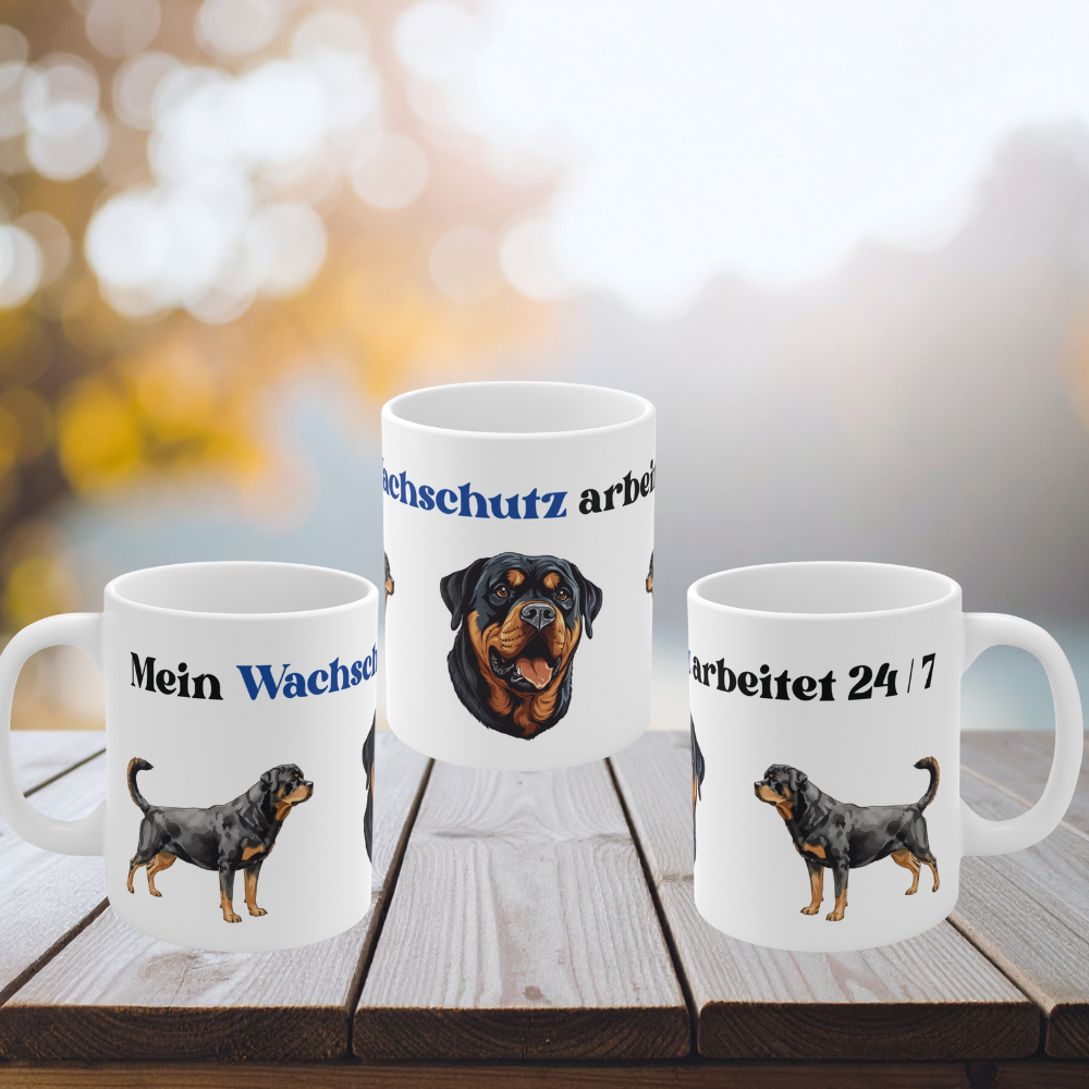 Weiße 330 ml Keramiktasse mit dem Spruch „Mein Wachschutz arbeitet 24/7“ sowie detailreichen Illustrationen eines Rottweilers.